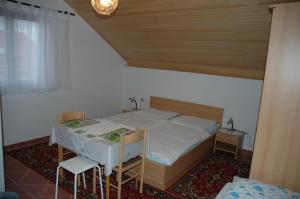 a small bedroom with a bed and two chairs at Apartment Latinovic in Vodice