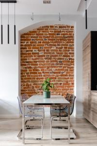 een eetkamer met een tafel en een bakstenen muur bij Apartament Rynek in Wrocław