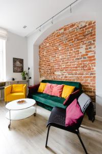 a living room with a couch and a brick wall at Apartament Rynek in Wrocław
