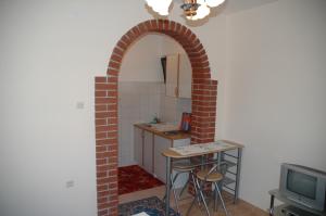 un arco en una cocina con mesa y TV en Apartment Latinovic, en Vodice