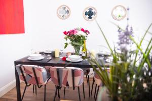a dining room table with chairs and a vase of flowers at 4bd Hidden gem by Brighton Station in Brighton & Hove
