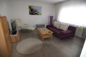 a living room with a purple couch and a table at Modern Apartment Wissenbach 1 in Eschenburg