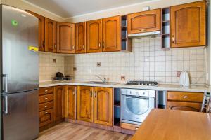 a kitchen with wooden cabinets and a stainless steel refrigerator at Most City area 1-bedroom apartment, central in Dnipro
