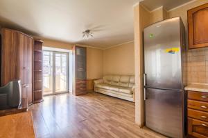 a kitchen with a stainless steel refrigerator and a couch at Most City area 1-bedroom apartment, central in Dnipro