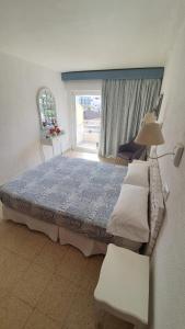 um quarto com uma cama grande e uma janela em Hostal Roberto em Palmanova