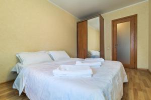 a white bed with towels stacked on top of it at Most City area 1-bedroom apartment, central in Dnipro