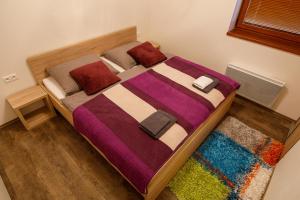 Dormitorio con cama con manta colorida y alfombra en apartmán ADAM Bystrá Tále en Bystrá