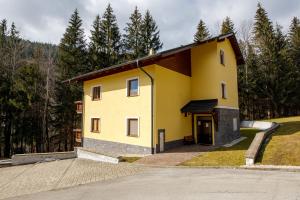 a yellow house on the side of a road at apartmán ADAM Bystrá Tále in Bystrá