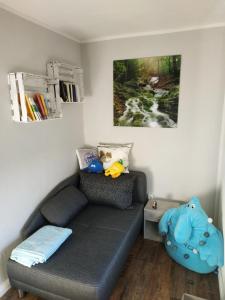 ein Wohnzimmer mit einem Sofa und einem Gemälde in der Unterkunft Projekt Ferienhaus am See inkl. W-LAN, Betwäsche und Netflix in Jürgenshagen