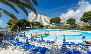 a pool with lounge chairs and a resort at Studio Rez de jardin Marina baie des Anges in Villeneuve-Loubet