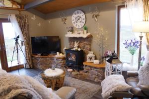 a living room with a stone fireplace and a tv at West Horizon holiday cottage in Lochinver