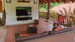 a living room with a couch and a flat screen tv at El Paraiso, Casa Campestre en Condominio, WiFi-Teletrabajo, Villeta in Villeta