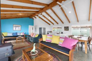 a living room with couches and a table at Bay Beach House - A Family & Pet Friendly Favourite with Direct Beach Access in Capel