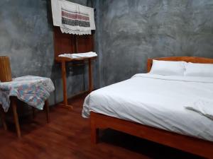 Postel nebo postele na pokoji v ubytování เฮือนไม้ชมนาด Huanmaichommanard