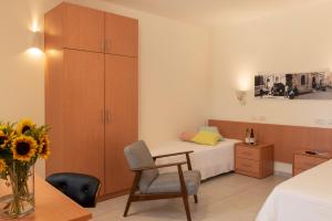 a bedroom with a bed and a desk and a chair at Austrian Pilgrim Hospice in Jerusalem