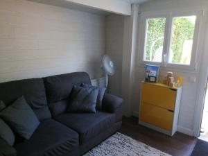 een woonkamer met een bank en een raam bij Petite habitation meublée in Biganos