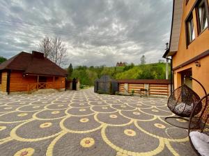 een patio met een stenen vloer voor een gebouw bij U Troh Brativ in Plavie +9 foto's