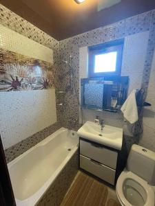 a bathroom with a tub and a toilet and a sink at U Troh Brativ in Oryava
