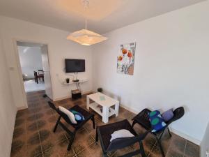 a living room with chairs and a tv and a table at Holiday Home Prišćapac in Prizba