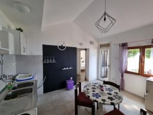 a kitchen with a table and a small table and chairs at Holiday Home Prišćapac in Prizba +22 photos
