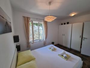 a bedroom with a white bed and a window at Holiday Home Prišćapac in Prizba
