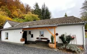 a white house with a porch with a bench at Gästehaus An der Berbke in Arnsberg