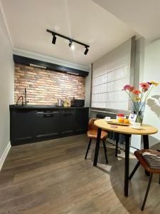 a kitchen with a table and a brick wall at Студия в современном стиле in Pavlodar +24 photos