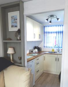 a kitchen with white cabinets and a sink at Dartmouth Chalet Holidays in Dartmouth