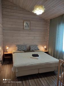 a bedroom with a bed with two tables and two lamps at Travel inn Villas in Velikiy Novgorod