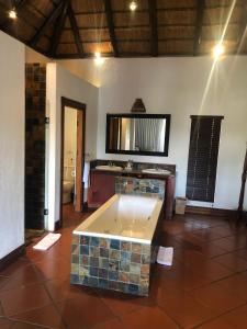 a bathroom with a tub in the middle of a room at Kruger Private Lodge in Marloth Park