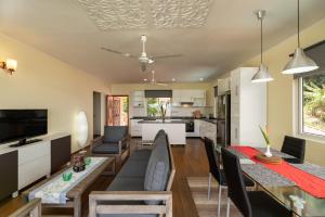 uma sala de estar e cozinha com mesa de jantar e cadeiras em Glacis Heights Villa em Glacis