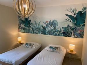 two beds in a room with a painting on the wall at MAISON MIGNARDISE - Cité in Carcassonne +37 photos