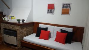 - un lit avec des oreillers rouges et noirs dans l'établissement De Las Artes XII - triplex sólo familias, à Pinamar