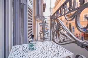 uma garrafa de vidro sentada numa mesa na varanda em Spagna Boutique em Roma