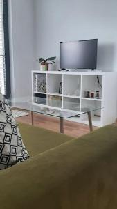 un salon avec une télévision et une table en verre dans l'établissement Rowing Base Apartment, à Plovdiv