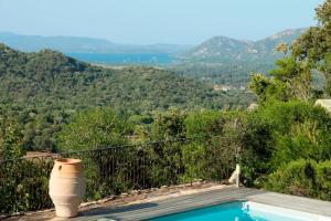 a swimming pool with a view of the mountains at Sublime vue sur mer et montagne in Porto-Vecchio