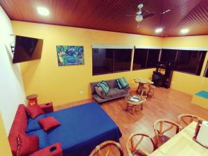 ein Wohnzimmer mit einem blauen Bett und einem Sofa in der Unterkunft Casa Córa in Heredia