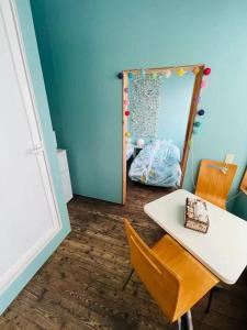 ein blaues Zimmer mit einem Tisch und einem Spiegel in der Unterkunft ハセノ島　Hotel　Cottage in Kamakura