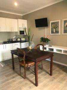 a kitchen with a wooden table and a dining room at Langebaan Golf Studio B1 - Langebaan Golf Estate in Langebaan