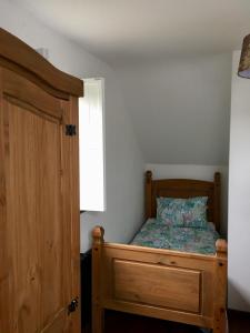 een slaapkamer met een houten bed en een raam bij Fernery Garden cottage, near Skibbereen in Drishanebeg