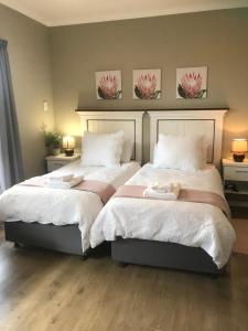 a bedroom with two beds with towels on them at Langebaan Golf Studio B1 - Langebaan Golf Estate in Langebaan +18 photos