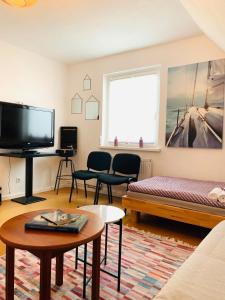a living room with a tv and a couch and a table at Luhne Boutique Pension in Rotenburg an der Wümme