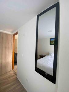 a mirror on a wall next to a bedroom at Hermoso apartamento in Barbosa