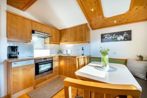 a kitchen with wooden cabinets and a table and chairs at Haus Gumpold 2 in Wagrain