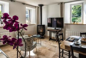 a living room with a table and a tv at Au fil de l'eau in Le Vast