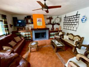 sala de estar con muebles de cuero y chimenea en Villa Elisabeth, en Granada