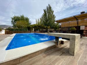 a swimming pool with a stone bench next to a table at Villa Elisabeth in Granada