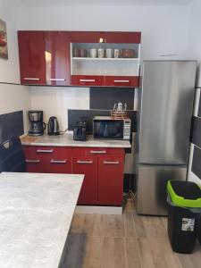 a kitchen with red cabinets and a stainless steel refrigerator at Duisburg Beeck in Duisburg