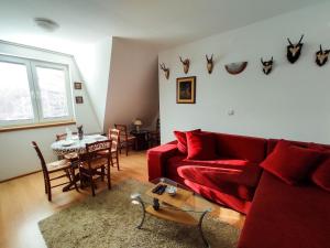 a living room with a red couch and a table at BonaMi Divcibare in Divčibare
