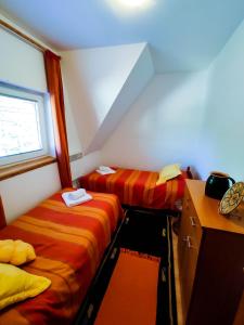 a room with two beds and a desk and a window at BonaMi Divcibare in Divčibare